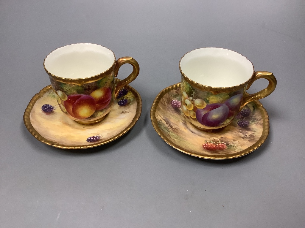 A pair of Royal Worcester fruit painted coffee cups and saucers, signed Freeman, (one saucer signed P. Love) 11cm